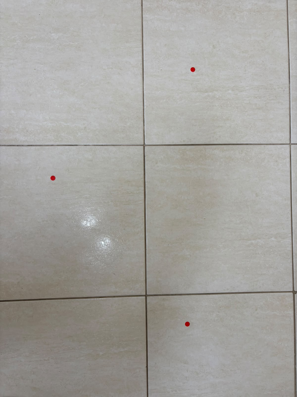Piso cerâmico com pontos identificados por adesivos vermelhos durante a vistoria